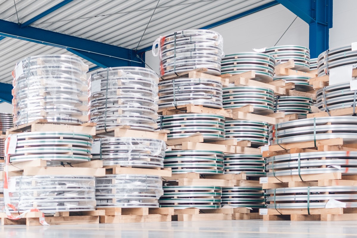 Workers looking at industrial materials in inventory of warehouse