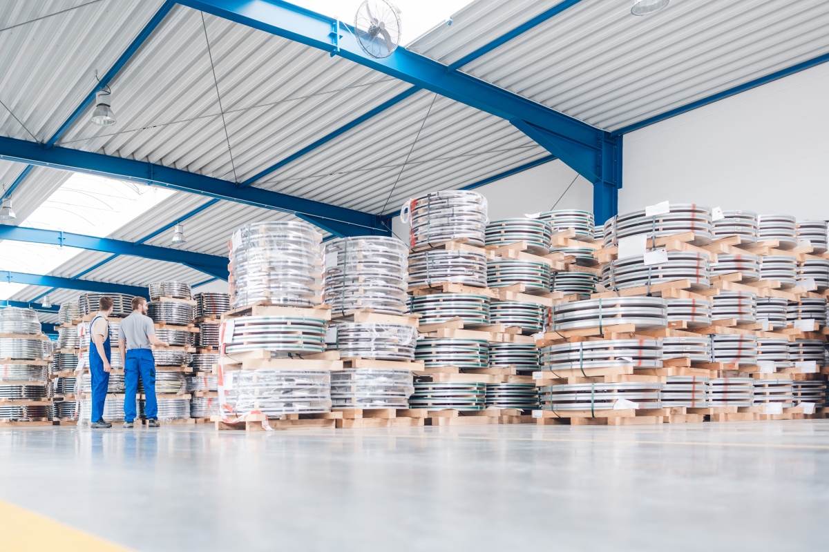 Workers looking at industrial materials in inventory of warehouse